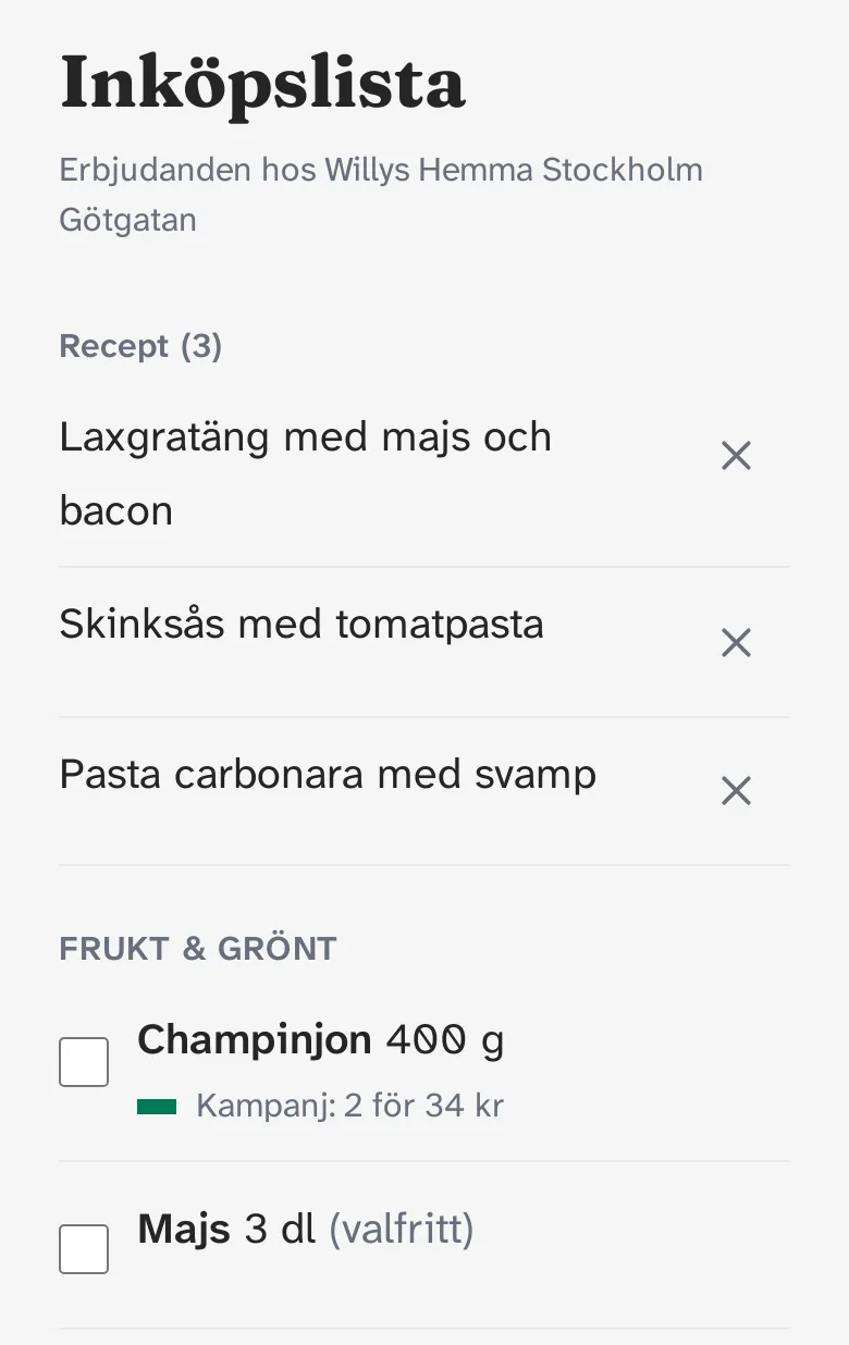 Inköpslistan i mobilen med erbjudanden hos Willys Hemma Stockholm Götgatan. Överst tre recept: Laxgratäng med majs och bacon, Skinksås med tomatpasta och Pasta carbonara med svamp, vart och ett med ett kryss för att ta bort det. Under rubriken Frukt och grönt: champinjon 400 g med kampanj 2 för 34 kr, och majs 3 dl, valfritt.